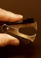 Man holding staple remover in fingers