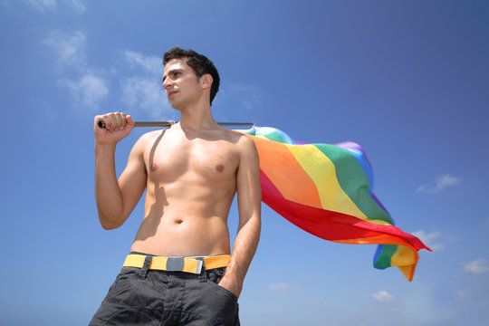 Young man holds a rainbow flag.
