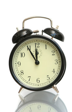 The black alarm clock is isolated on a white background