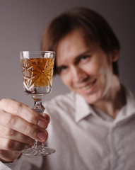Man with glass of wine in right hand. Focus on the wineglass.