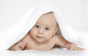 Fototapeta na wymiar Little baby pod białym ręcznikiem