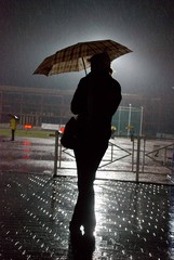 lonely figure on the light athletic stadium under the rain