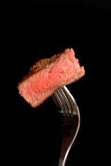 Un morceau de bifteck de faux-filet grillé sur une fourchette