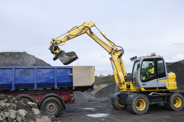 digger loading waiting truck