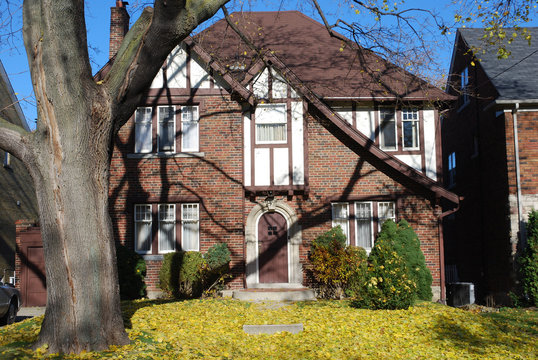 tudor style home with leaf covere lawn