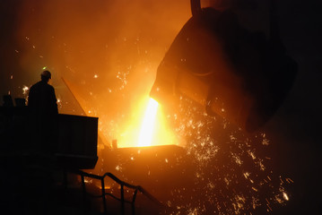 a dramatic scene inside a foundry or steel mill