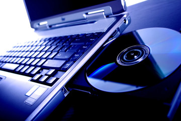 laptop with a disk dvd. blue tone - obrazy, fototapety, plakaty