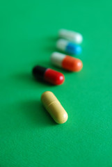 pills on green background in row