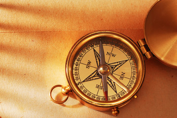 Antique brass compass over old background