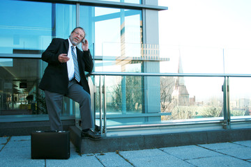 Business man with a modern building behind him