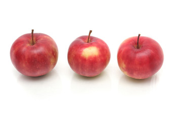 Three red apples on a white background
