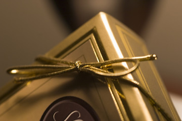 A pretty gift box with gold color ribnon tie