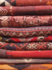 Red turkish carpets stacked in a traditional store