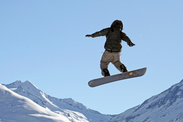 Snowboarder über den Bergen fliegend