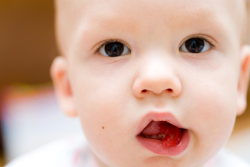Baby eating apple. Children's face close-up
