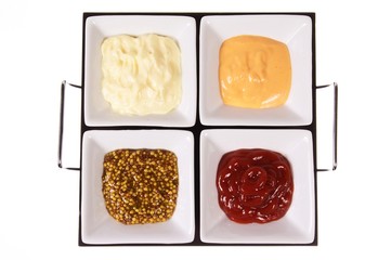 four sauces in white dishes - top view