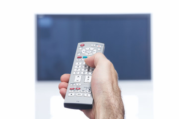 Hand with remote control and flat tv