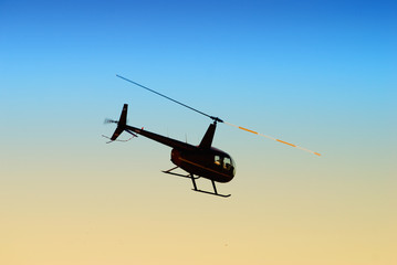 Fototapeta na wymiar helikopter latający na wieczornym niebie