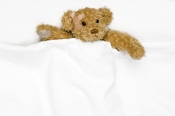 Teddy bear as a patient in bed