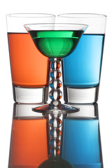 Colorful drinks on a reflective tabletop.