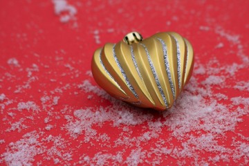 Christmas heart on the red background with snow 