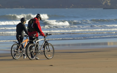 Fototapeta na wymiar Pareja con bicicletas paseando por la playa