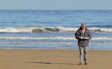 Hombre leyendo en la playa