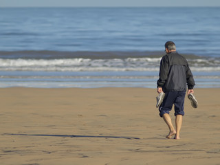 Hombre caminando por la playa