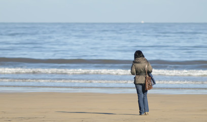 Mujer en la playa mirando el mar