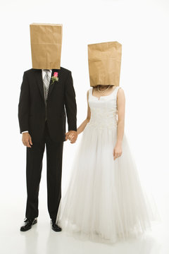 Wedding couple with bags over heads.