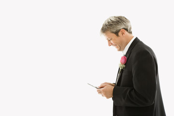 Groom texting on cellphone.