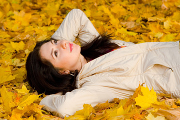 Young pretty women rest on the autumn leaf