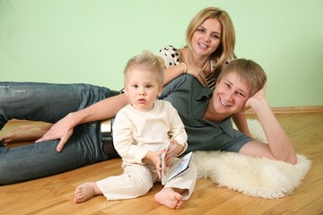 beautiful young family rest on wooden floor 