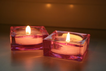 two candles in rose candlesticks