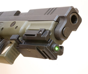 Semi-auto polymer pistol with a green laser attached on its accessory rail and activated.