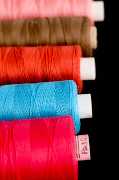 Spools of colorful thread in a row