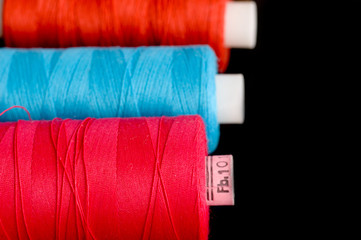 Spools of colorful thread in a row