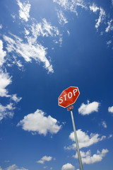 Stop sign with blue cloudy sky.