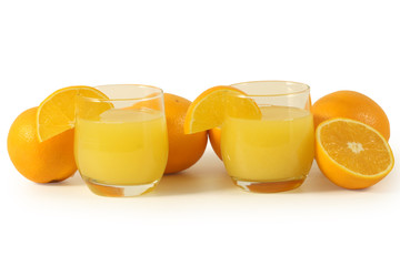 Glasses with orange juice and oranges
