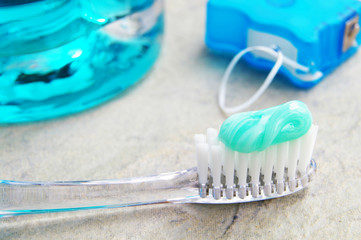 Closeup of a tooth brush, with floss and rinse