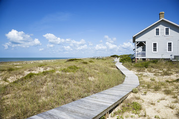 Beachfront house with wooden walkway. - 5331079