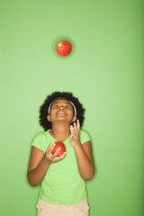African American girl juggling apples.