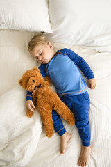 Toddler sleeping with bear.