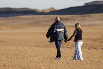 couple qui marche en se tenant la main sur la plage
