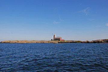 A picture of a calm,rocky coast and a lighthouse