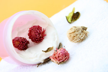 Spa essentials (cream, white towel and pink flowers) 
