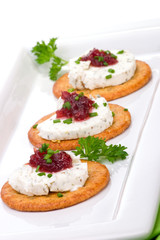 Three crackers with goat cheese and cranberry orange sauce