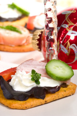 Closeup of cracker with cream cheese, ham, bell pepper