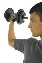 Fototapeta na wymiar Young man exercising arm muscles with dumbbell