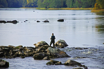 A women fishing at the river in Sweden.